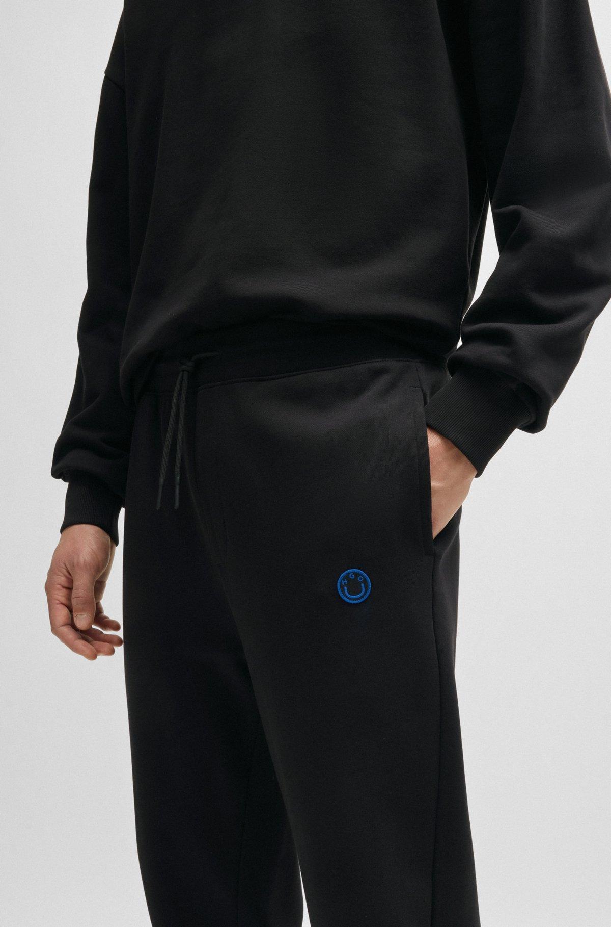 Cotton-terry tracksuit bottoms with Happy HUGO logo Product Image