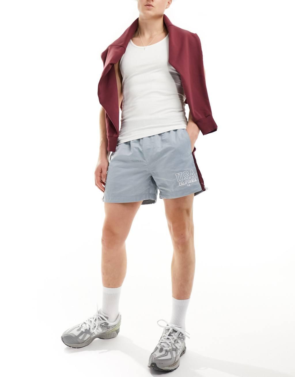 ASOS DESIGN nylon short with side stripe panel and embroidery in blue Product Image