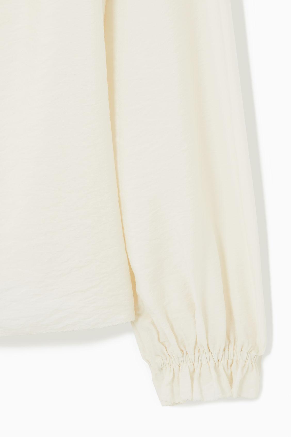 RUFFLED HIGH-NECK BLOUSE Product Image