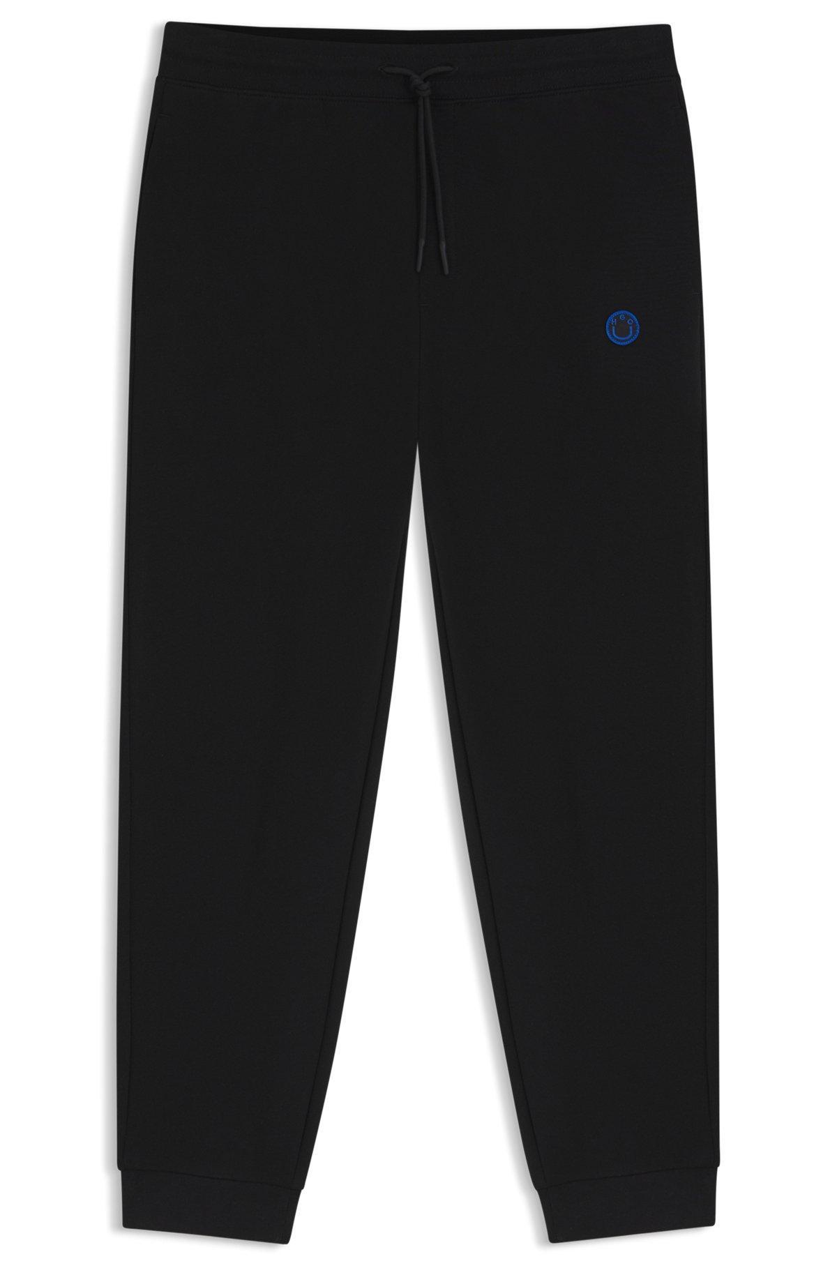 Cotton-terry tracksuit bottoms with Happy HUGO logo Product Image