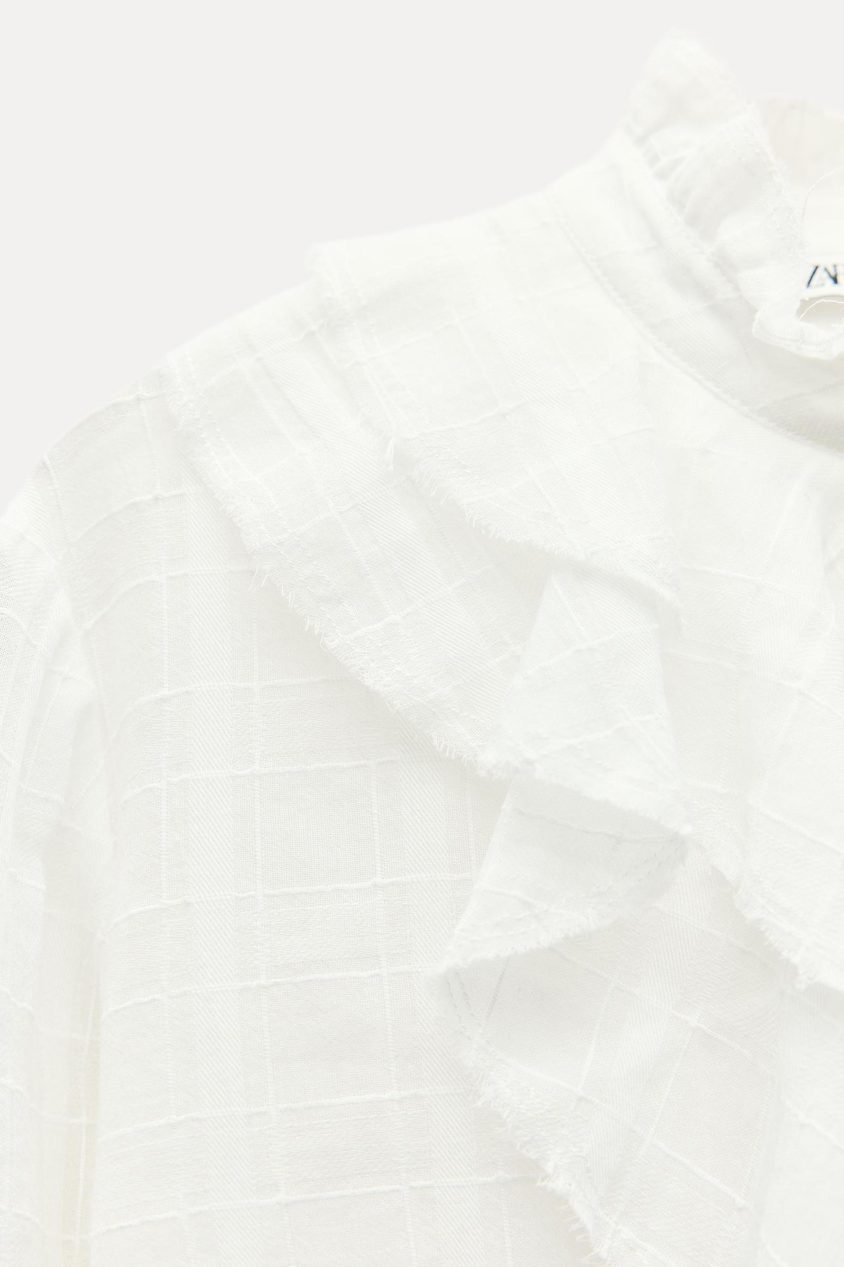 ZARA WOMAN COLLECTION<br/><br/>Blouse made with cotton. Round neck and long sleeves. Self ruffle detail. Front button closure. Product Image