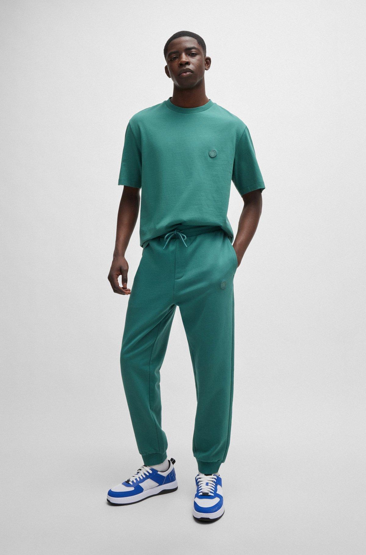 Cotton-terry tracksuit bottoms with Happy HUGO logo patch Product Image