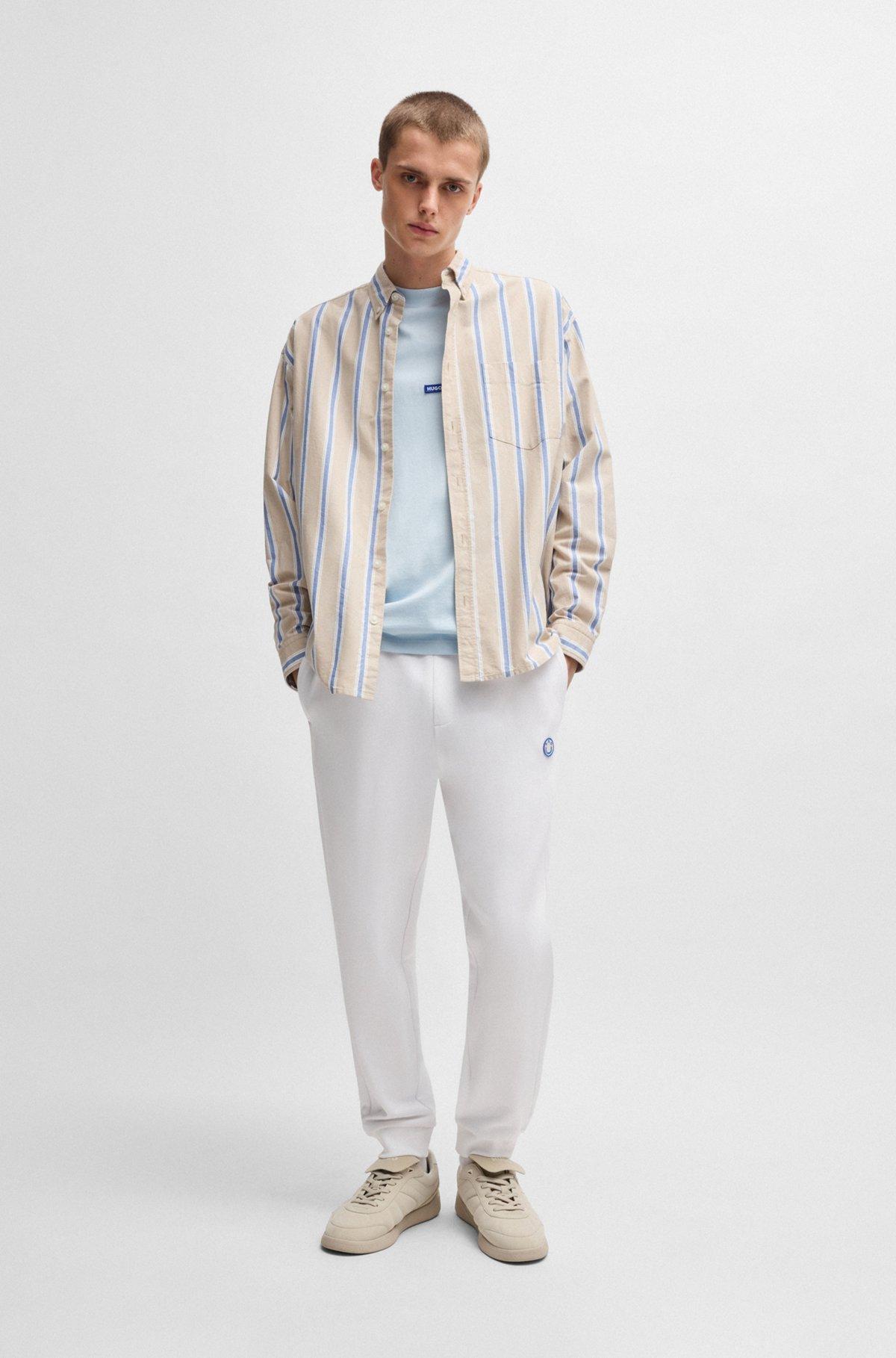 Cotton-terry tracksuit bottoms with Happy HUGO logo Product Image