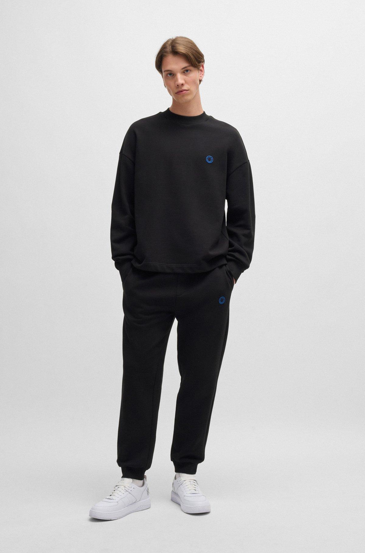 Cotton-terry tracksuit bottoms with Happy HUGO logo Product Image