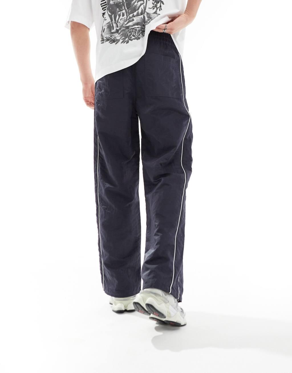 ASOS DESIGN baggy nylon track pants with white piping in navy  Product Image
