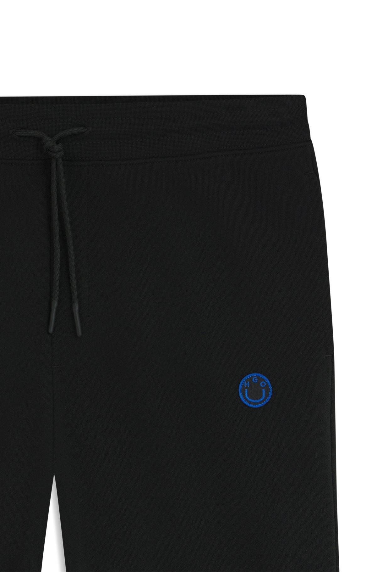 Cotton-terry tracksuit bottoms with Happy HUGO logo Product Image