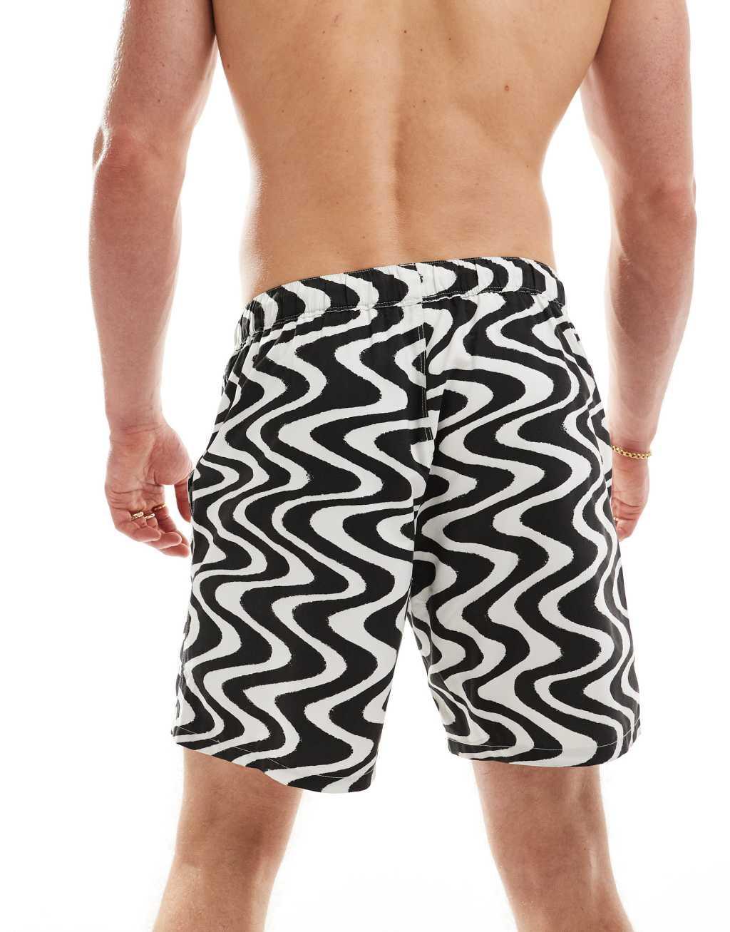 ASOS DESIGN swim shorts in mid length in black wave print Product Image