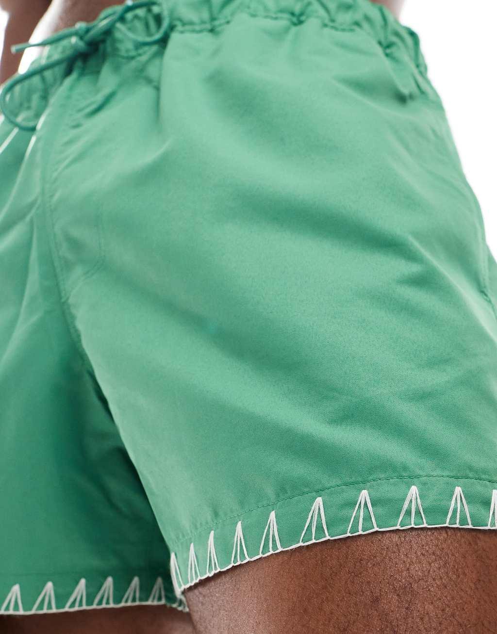 ASOS DESIGN swim shorts in short length in green with hem detail Product Image