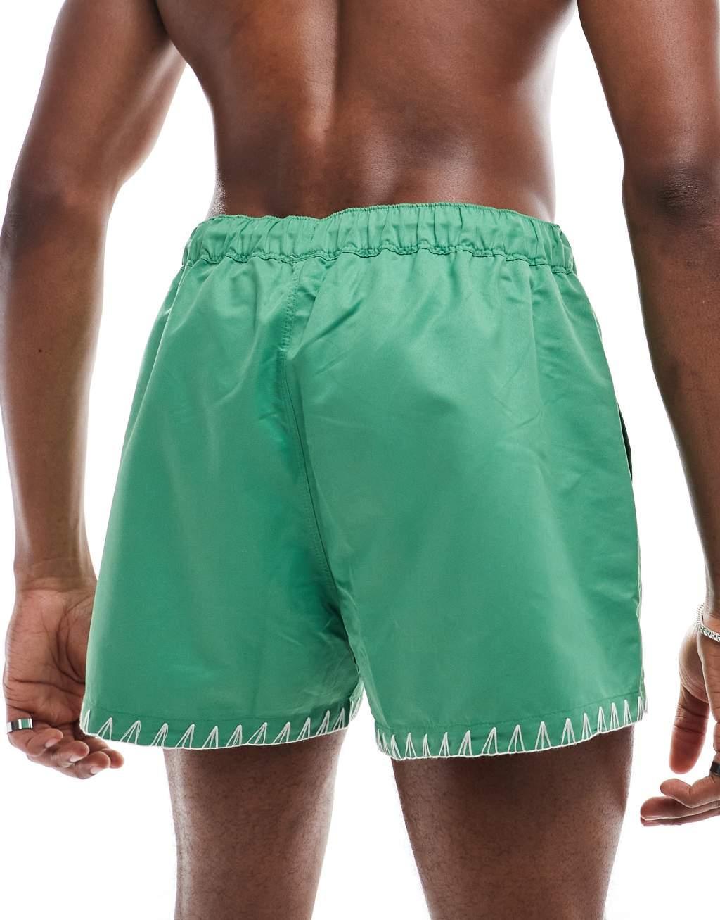 ASOS DESIGN swim shorts in short length in green with hem detail Product Image