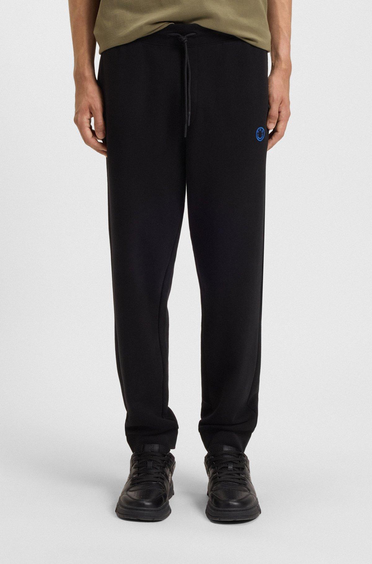Cotton-terry tracksuit bottoms with Happy HUGO logo Product Image