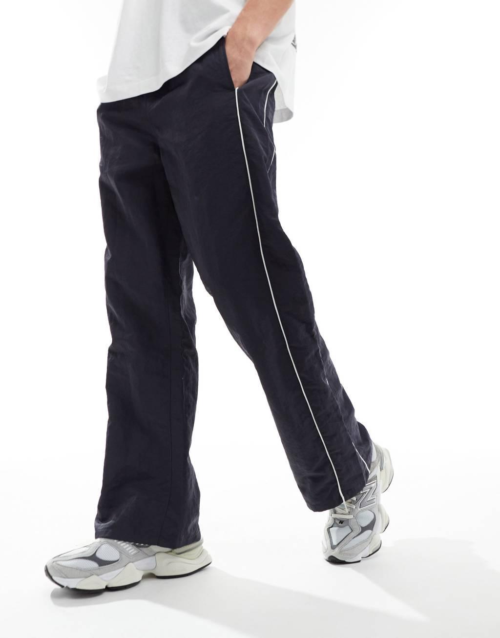 ASOS DESIGN baggy nylon track pants with white piping in navy  Product Image