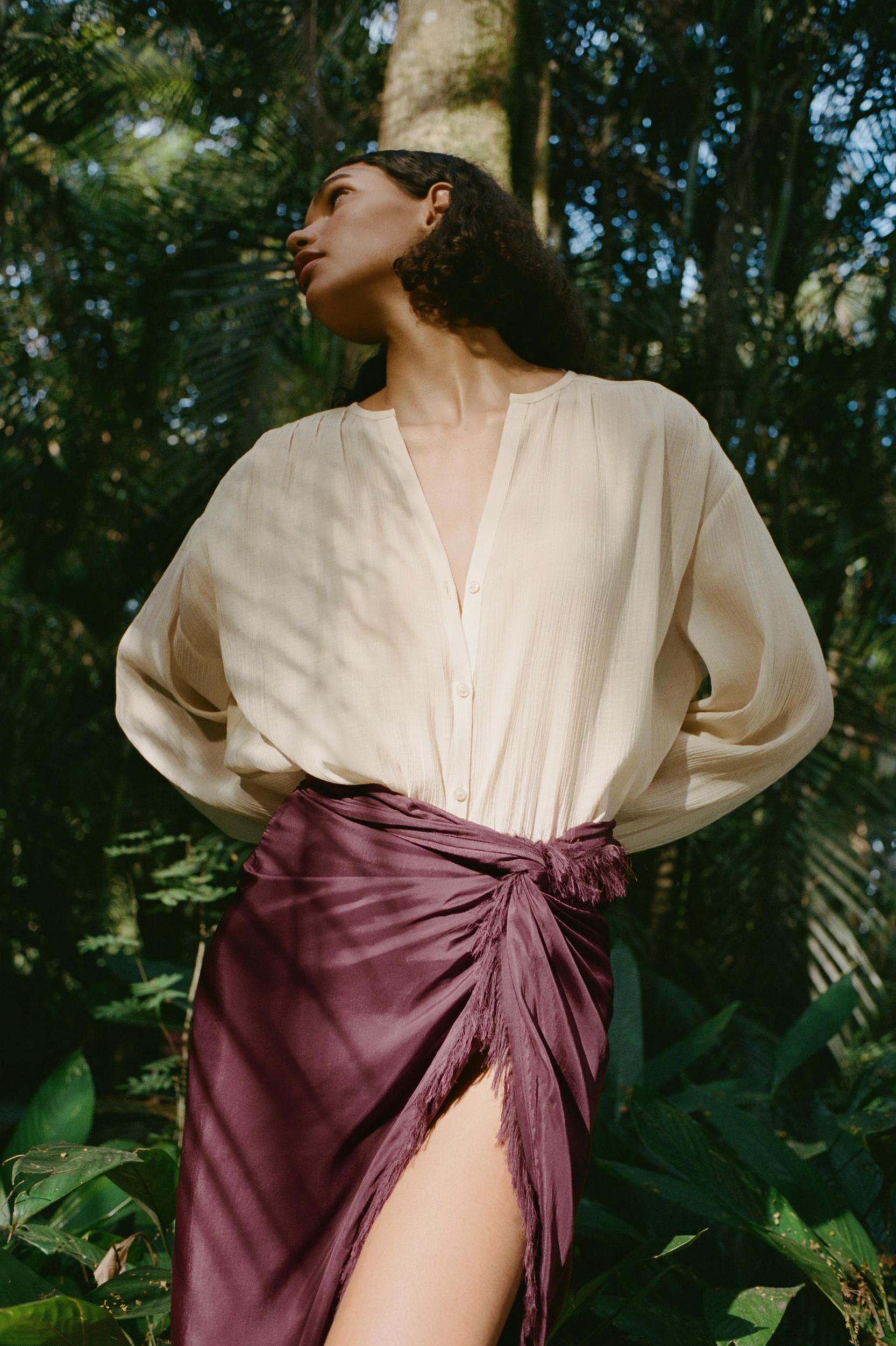 Round collar blouse with V-neck front and long balloon sleeves. Front button closure. Product Image