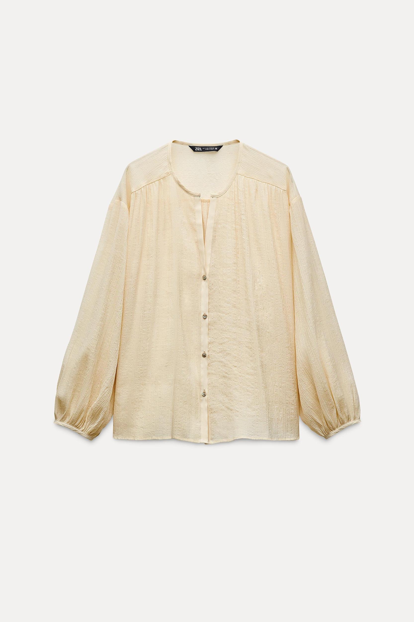 Round collar blouse with V-neck front and long balloon sleeves. Front button closure. Product Image