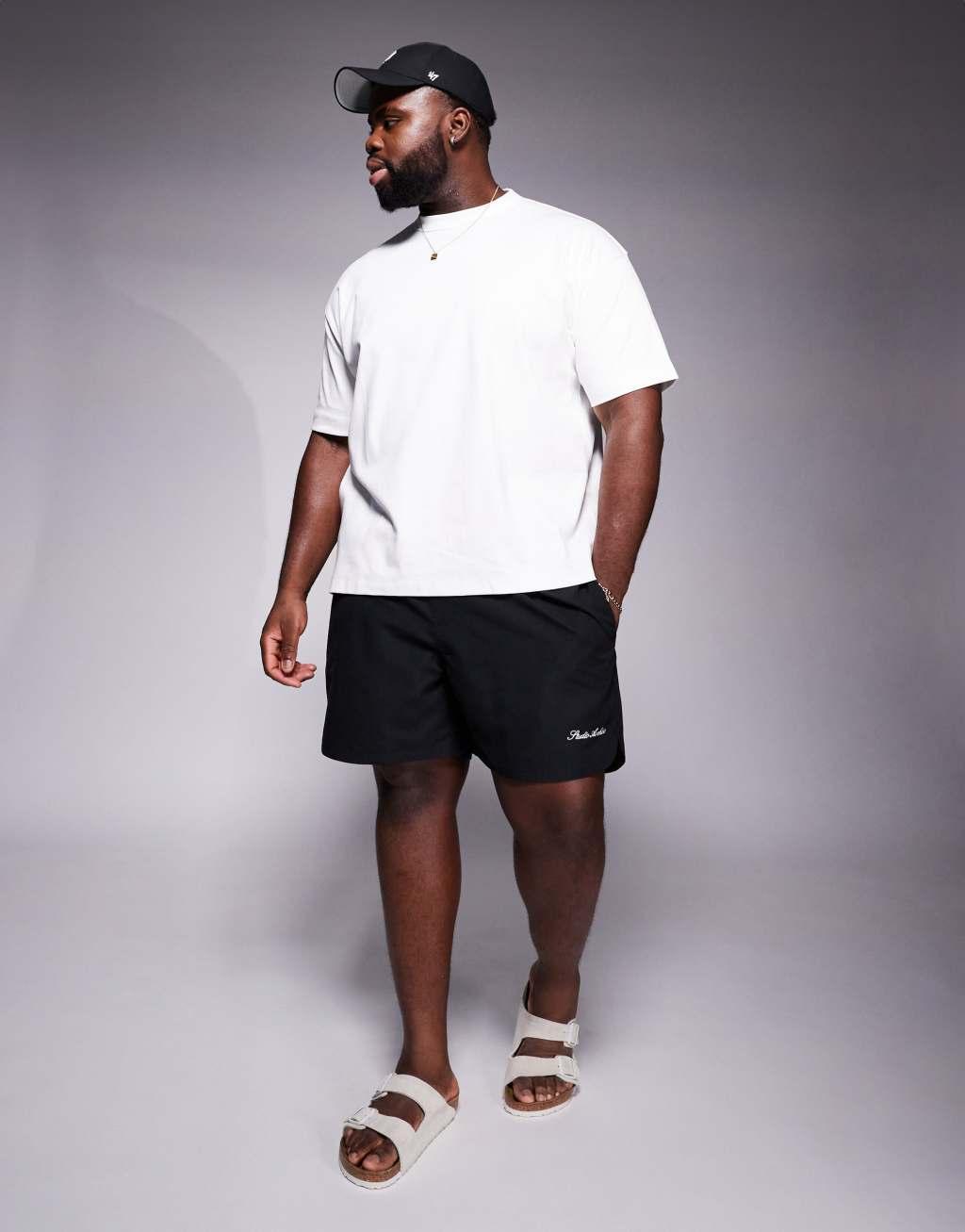 ASOS DESIGN swim shorts in mid length with embroidery placement in black  Product Image