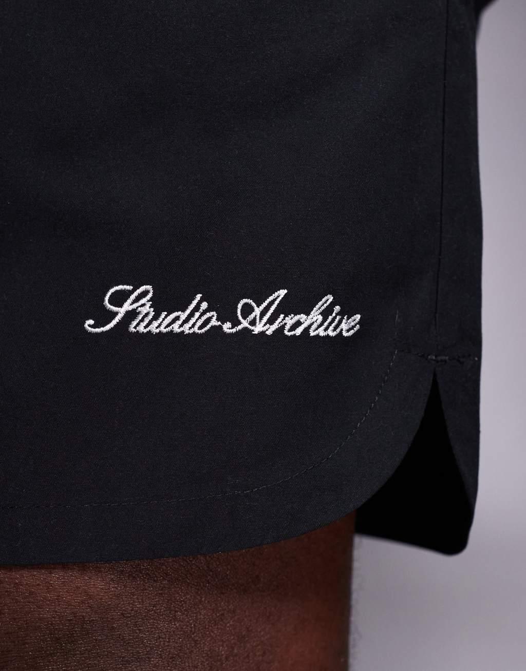 ASOS DESIGN swim shorts in mid length with embroidery placement in black  Product Image