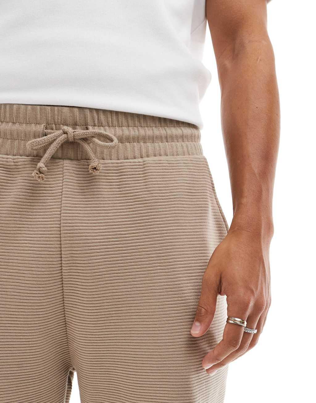 ASOS DESIGN tapered ribbed sweatpants in beige Product Image